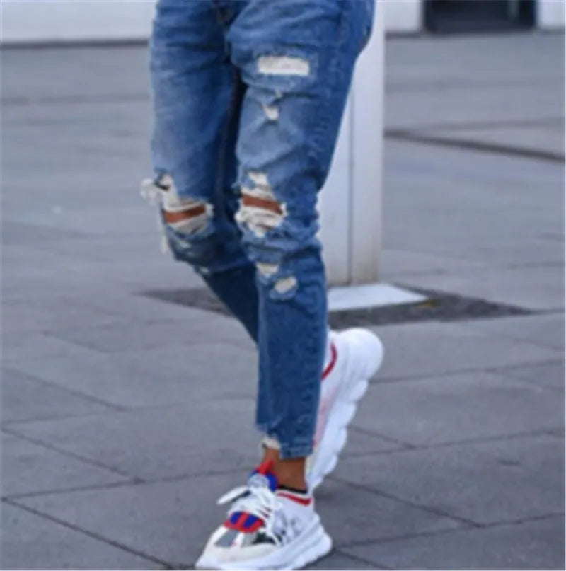 Men's deep blue cotton jeans on a hanger, showing the classic five-pocket design.