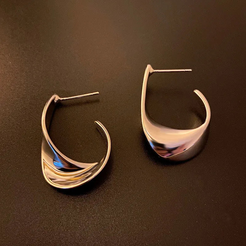 Metal twisted geometric earrings with round elements in gold or silver finish