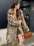 Long grey faux fur coat with a large fur collar and pockets on a model.