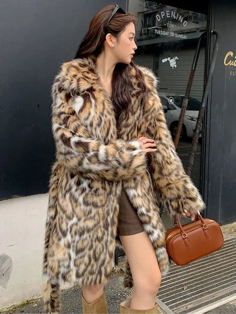 Long grey faux fur coat with a large fur collar and pockets on a model.