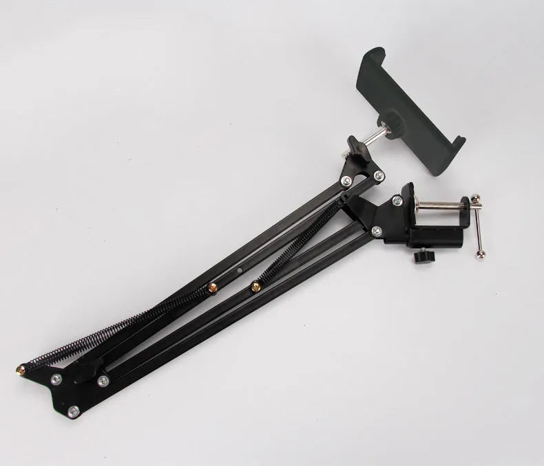 Black adjustable phone tablet stand with 360-degree rotating head on wooden desk