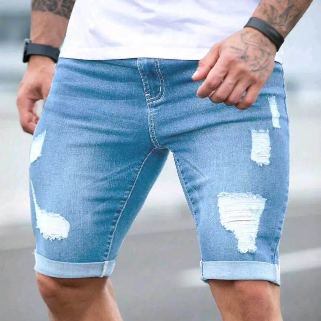 Men's sky blue denim shorts with multi-hole distressed design showing low waist and straight cut