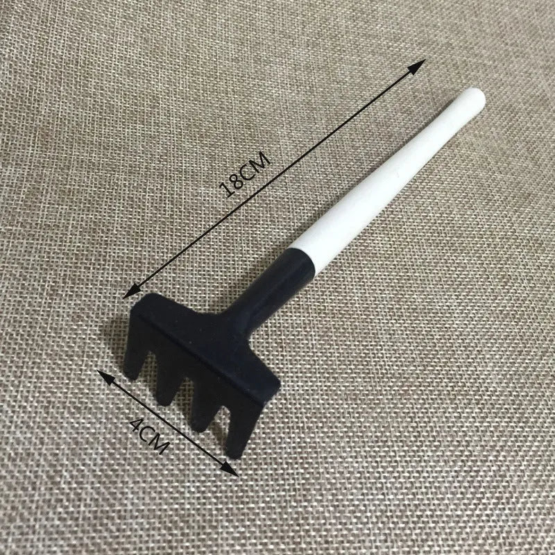 Succulent gardening tool set showing mini shovel, watering can, tweezers, brush, and rake on a table