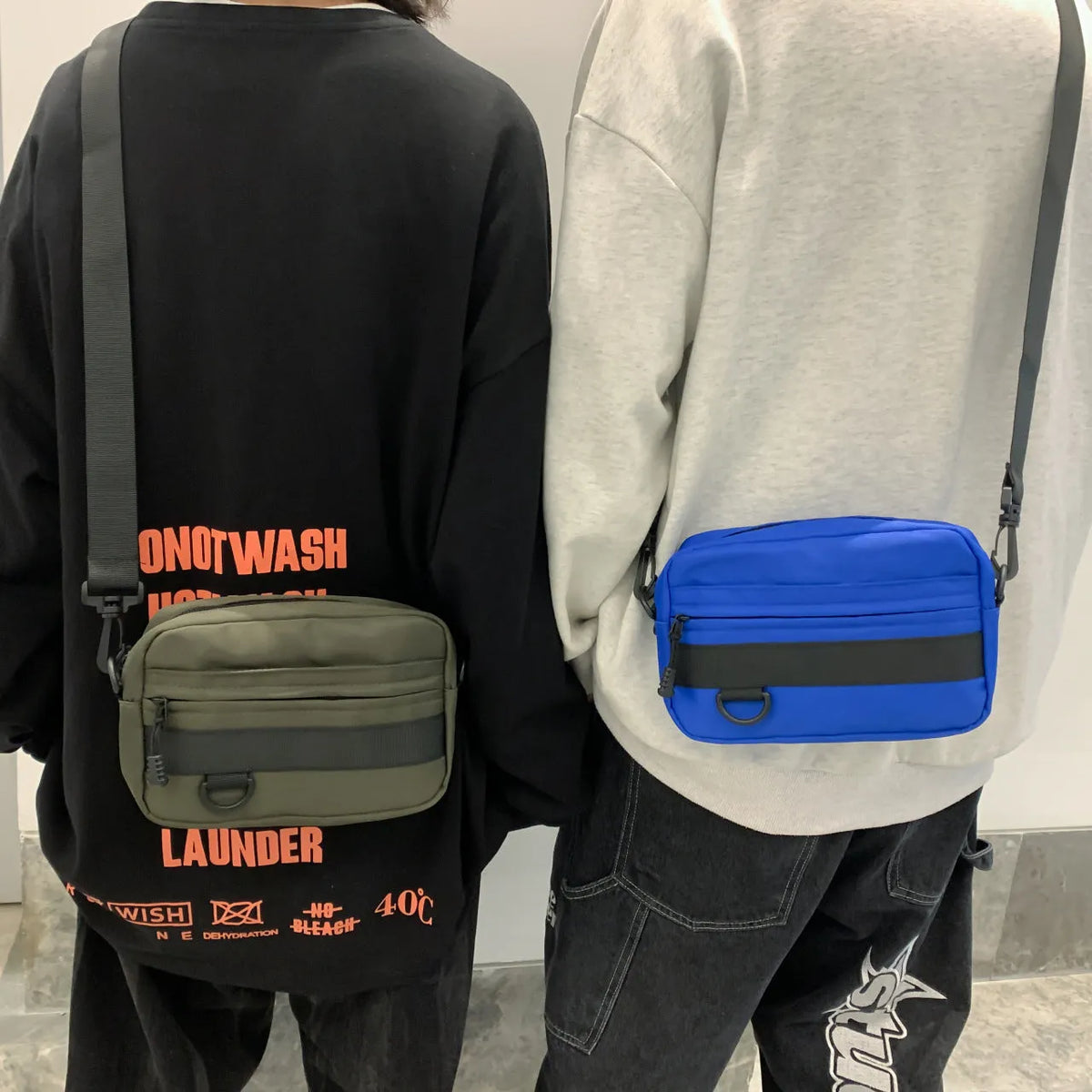 Men's street style nylon messenger crossbody bag in black showing 22cm length and sewing thread detailing