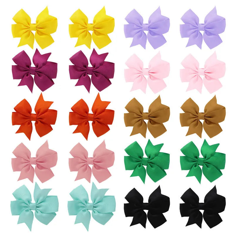 Assorted colour 3-inch grosgrain ribbon hair bows on alligator clips for toddler girls.
