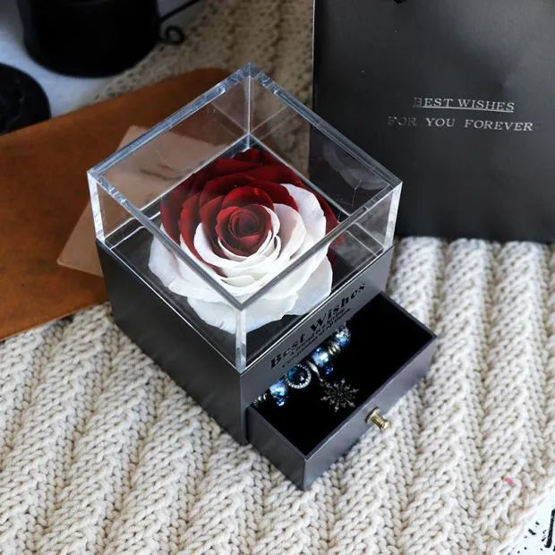 Glass eternal flower jewellery box with preserved roses and carnations inside measuring 8.5cm square