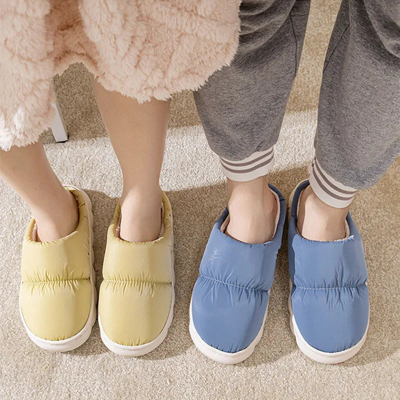 Blue winter indoor slippers with thick rubber sole and plush lining, shown on a hard floor.