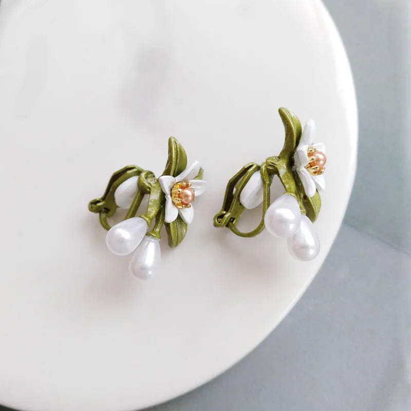 A pair of women's alloy flower earrings shown in two style options: sterling silver needle flowers and a coloured flower clip.