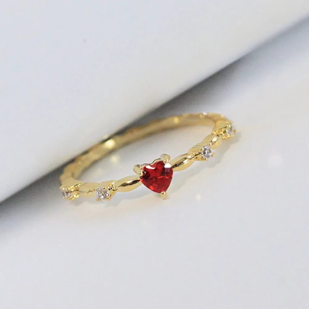 Gold or silver electroplated peach heart ring with zircon stones on a model's hand