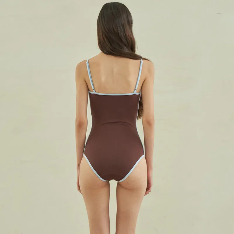 Brown women's triangle one-piece swimsuit on a hanger.