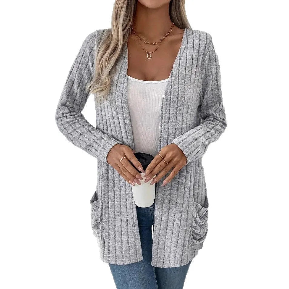 A solid colour long sleeve cardigan with pockets, shown in a loose fit on a model.