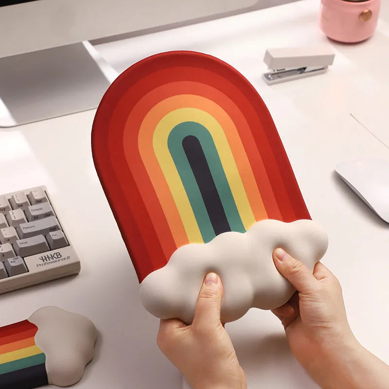 Silicone wrister mouse pad and keyboard support set with printed white cloud pattern on a desk.