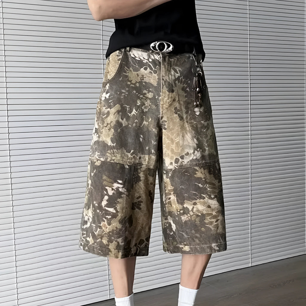 Men's yellow denim jeans with a snake pattern and camouflage tooling print, showing cropped leg length.