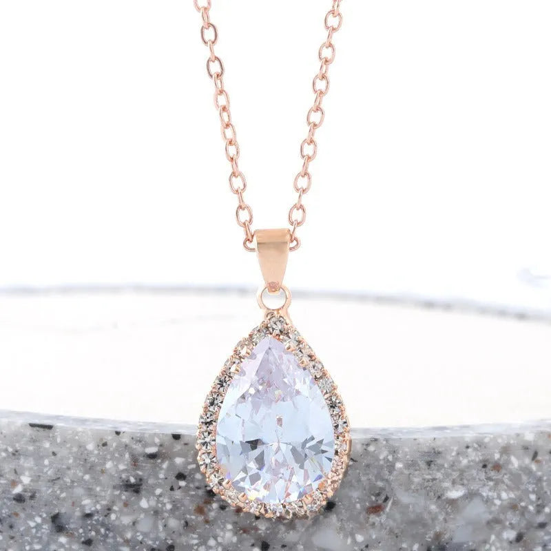Water drop shaped pendant necklace with geometric design and rhinestone accents in pink colour