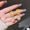 Gold Hong Kong style flower stud earrings with needle rose pearl design and opal stones
