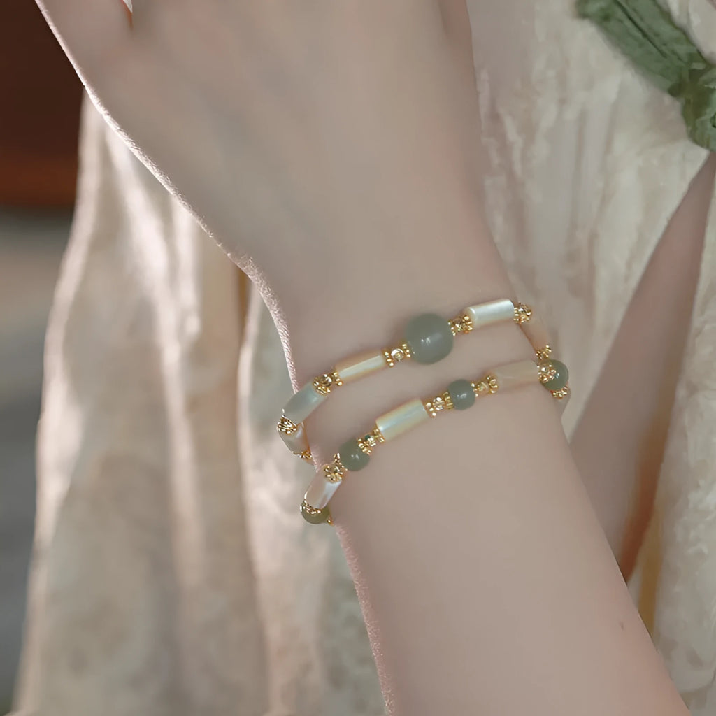 Simple geometric white Hetian jade bead bracelet for women on a wrist.