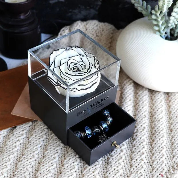 Glass eternal flower jewellery box with preserved roses and carnations inside measuring 8.5cm square