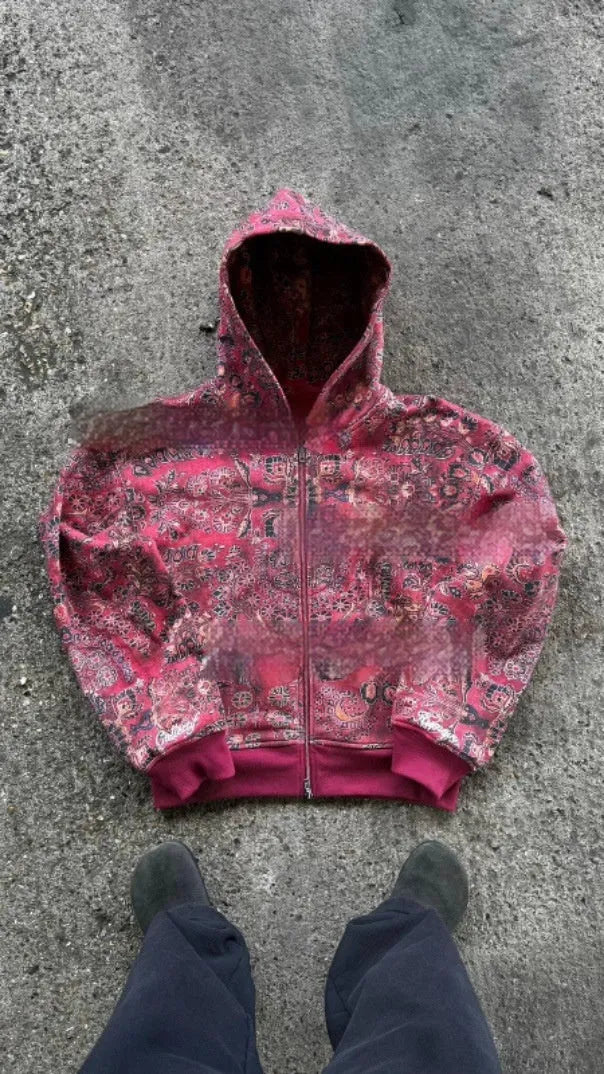 A man's loose-fitting zip-up hooded coat in red or blue with a digital print design.