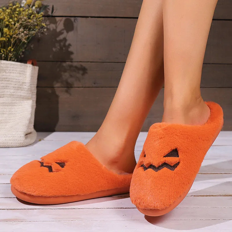 Orange Halloween pumpkin-themed plush slippers with a coral velvet upper and non-slip sole.