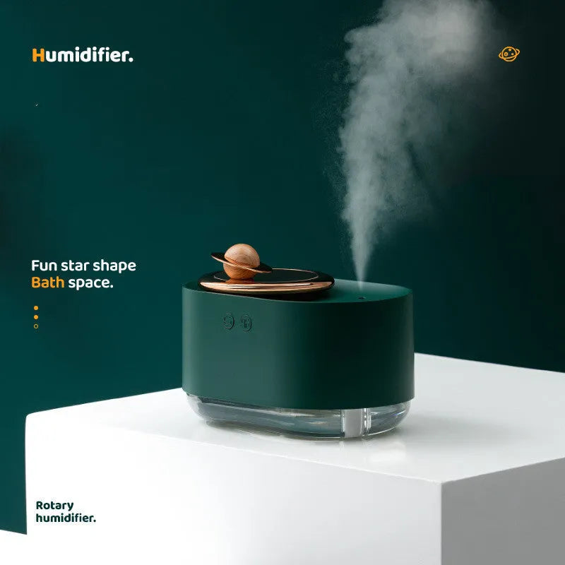 Green rotating planet USB humidifier with night light on a wooden desk