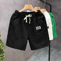 A pair of solid-colour casual sports shorts made from polyester, shown in white, suitable for beach and outdoor activities.
