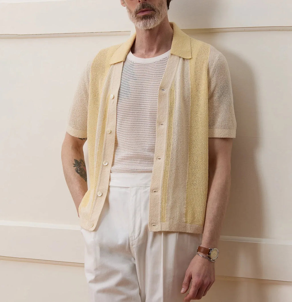 A bright yellow men's short-sleeved polo shirt with hollow-out asymmetric patterning on a casual model.