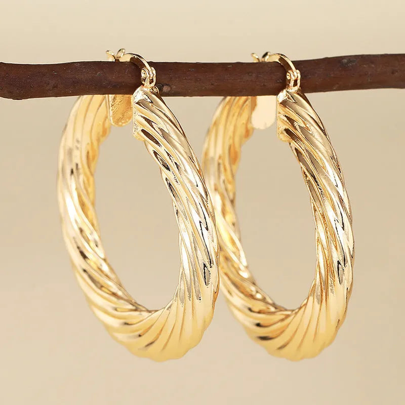 Geometric drop-shaped women's ear clip with ring design in electroplated copper.