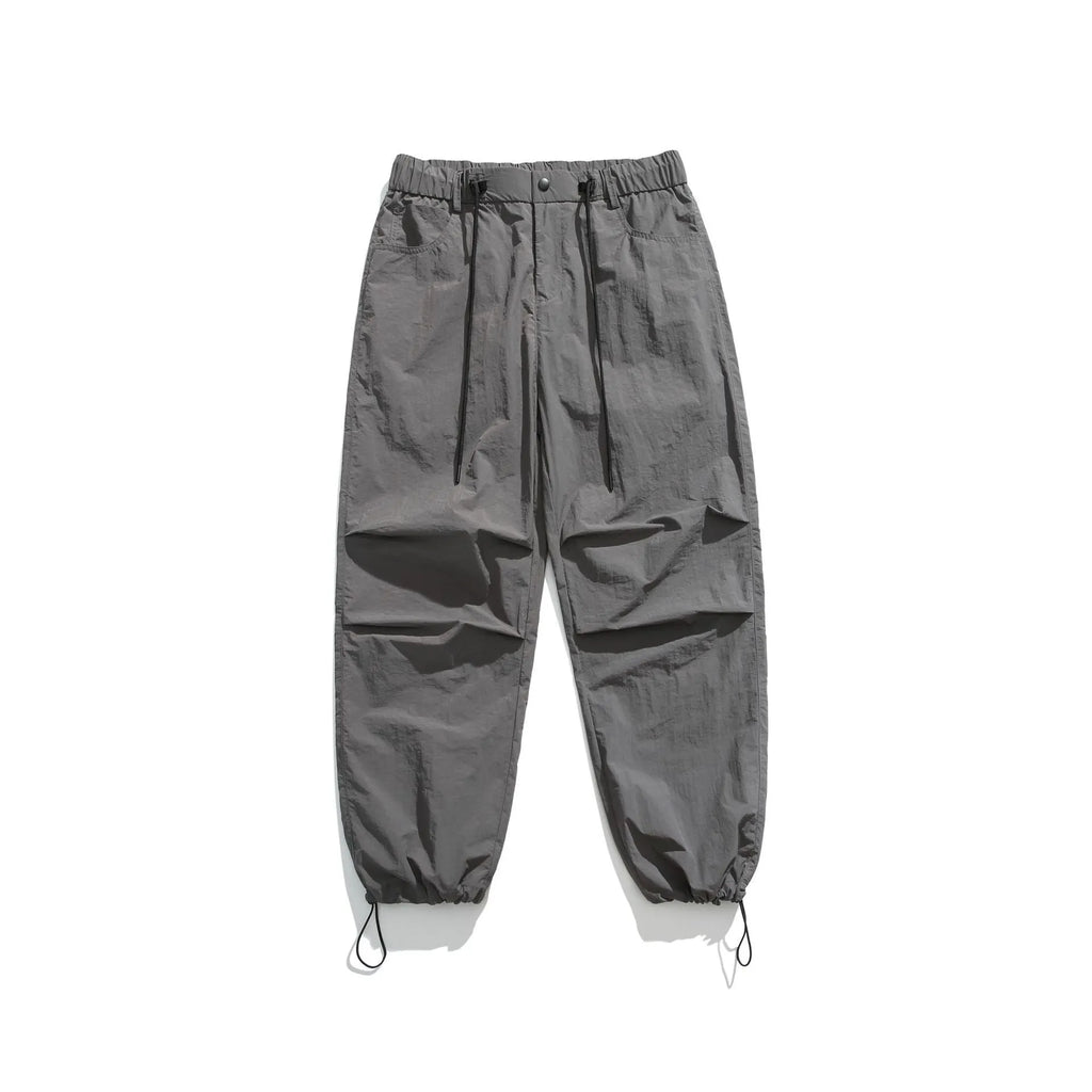 Man wearing loose straight-leg casual trousers in thin ice silk nylon fabric, shown in khaki colour.