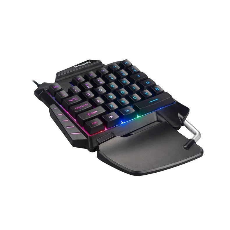 Black left-handed one-handed gaming keyboard with palm rest and shortcut keys on a desktop.
