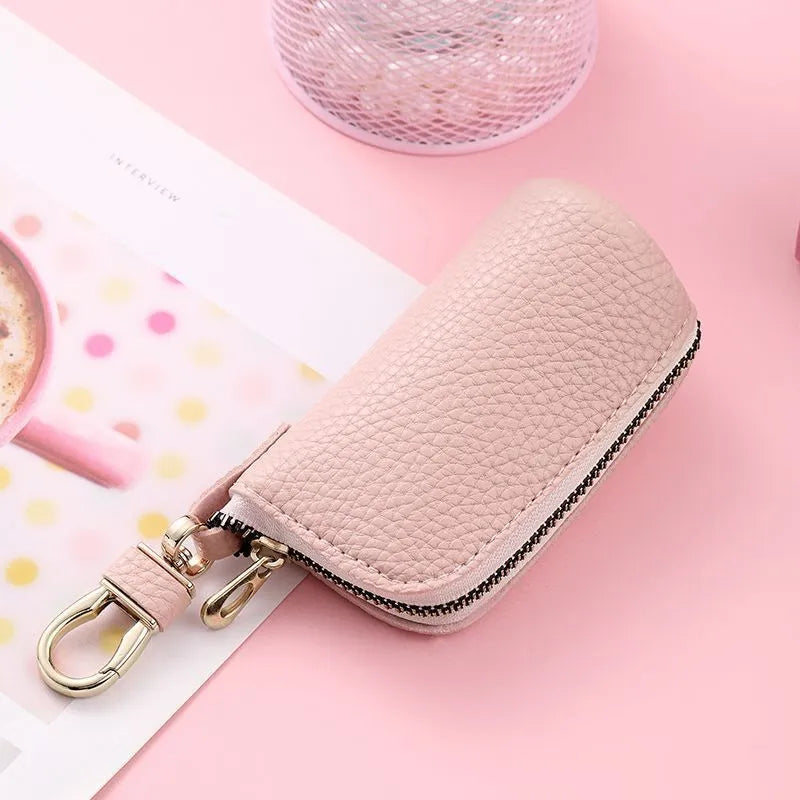 Simple black PU leather zipper key ring for car keys on a grey background.