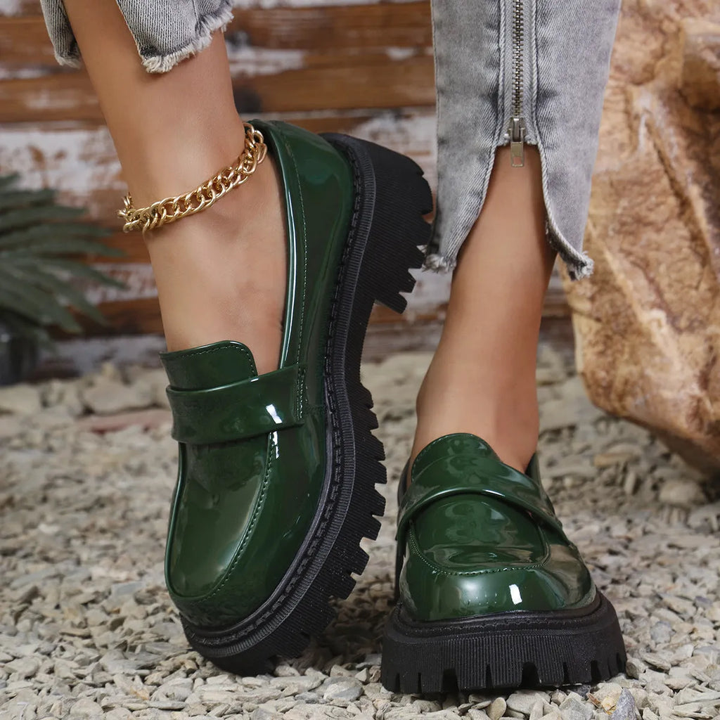 Women's plus size black slip-on loafers with a chunky platform heel and rubber sole.