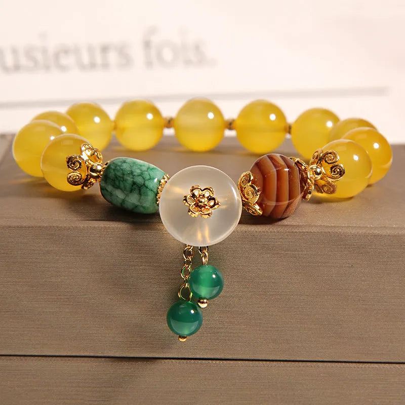 Adjustable khaki bracelet with large yellow agate bead on gold silk cord.