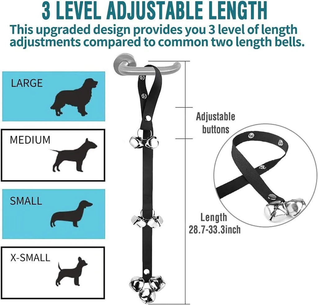 Silver metal dog training bells on an adjustable black nylon strap hanging from a door
