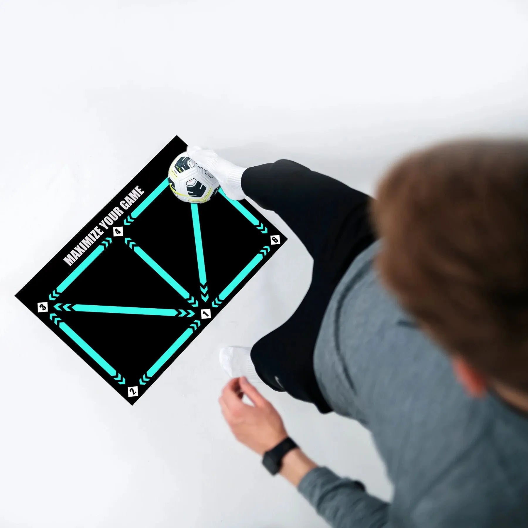 Black football training mat on a flat surface, dimensions 60cm by 90cm.
