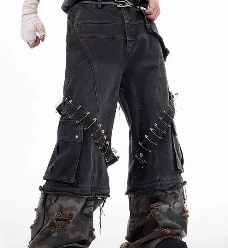 Men's grey cotton jeans with camouflage print, splicing panels, and decorative pin and ribbon details.