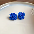 Women's cloth geometry earrings with blue resin flower detail on silver needle, manual craft construction