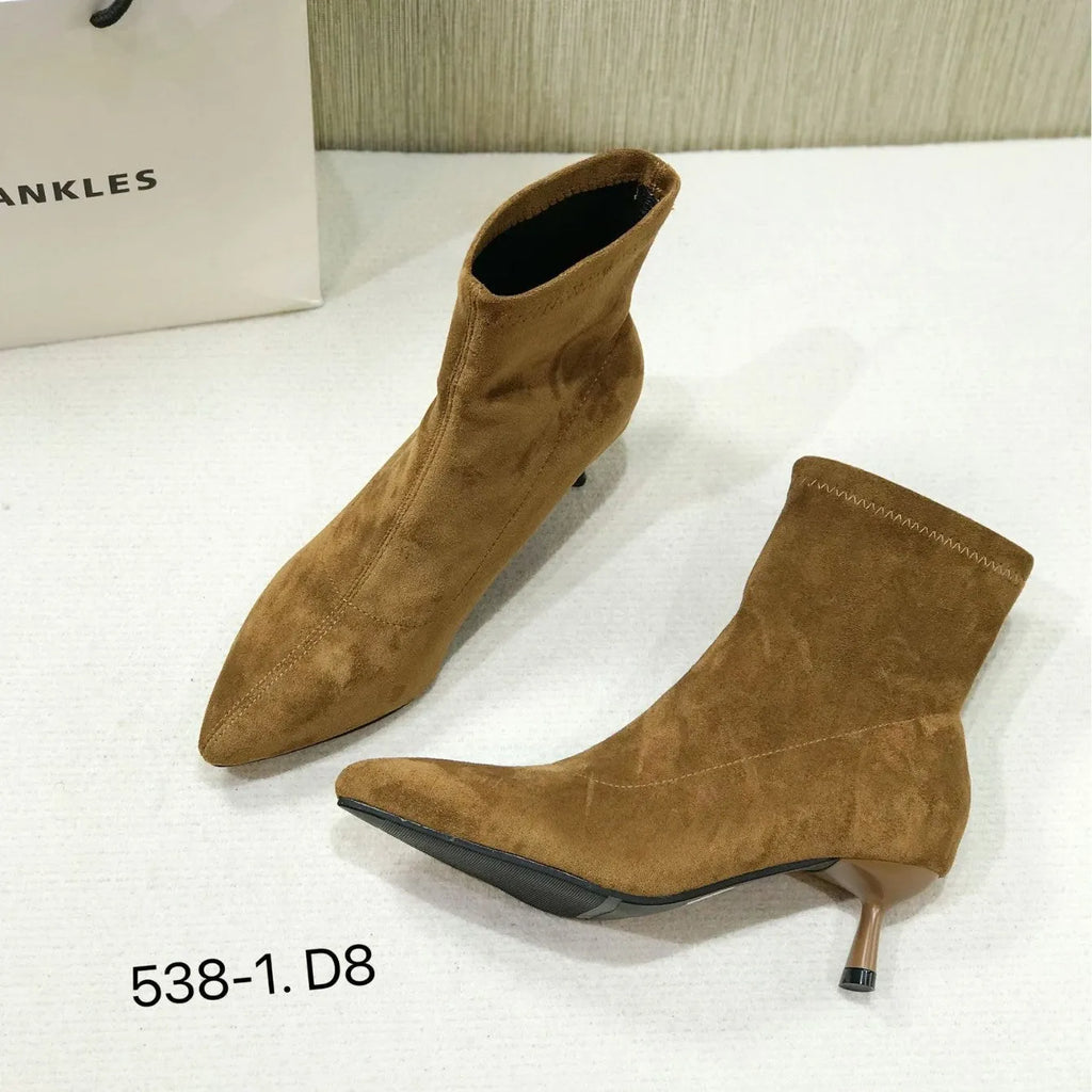 Black pointed toe women's ankle boots with stiletto heel on a plain background
