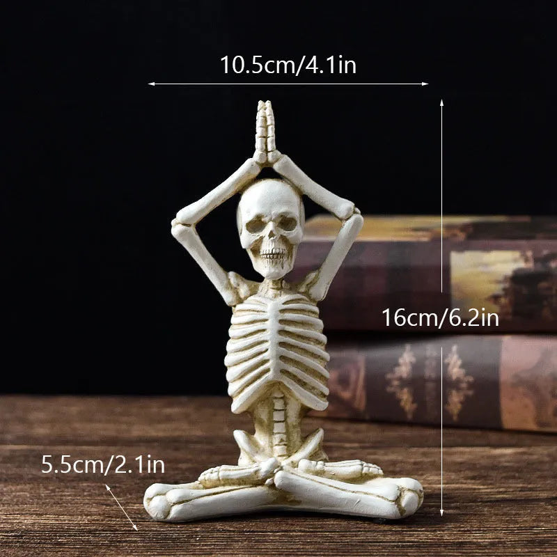Detailed resin Halloween ornament of a yoga-posing skeleton skull on a desktop.