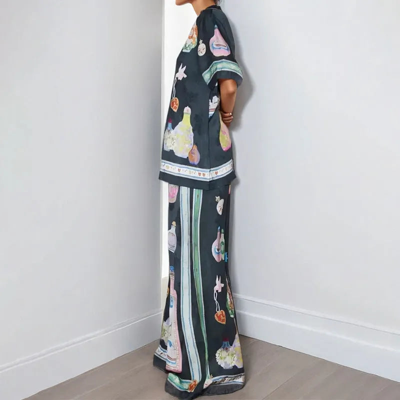 Women's black casual matching set with cartoon animation print, featuring a cardigan sleeve top and trousers