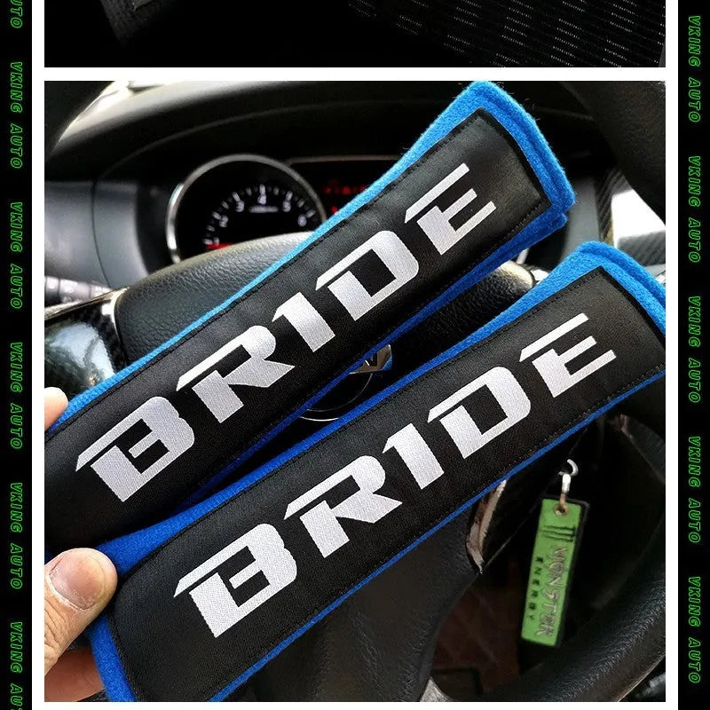 Pair of black car seat belt shoulder pads made from cotton sponge cloth, showing embroidery detail.