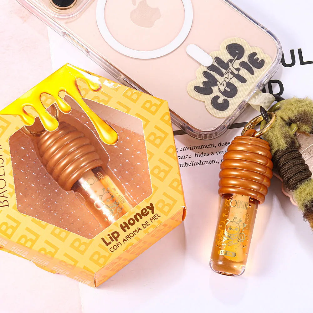 Portable honey lip gloss with keychain attached to bag strap