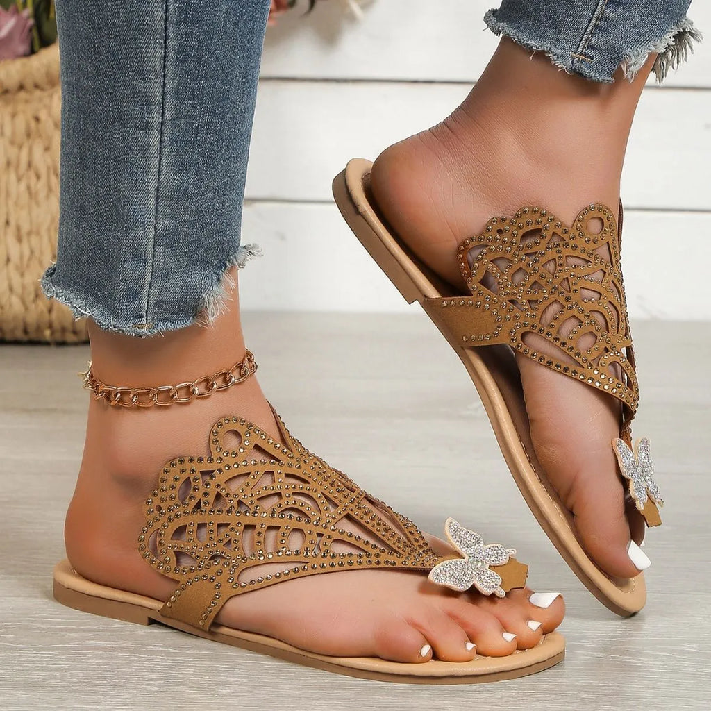 Women's black slip-on sandals with rhinestone detail and flip-toe design on a rubber sole.