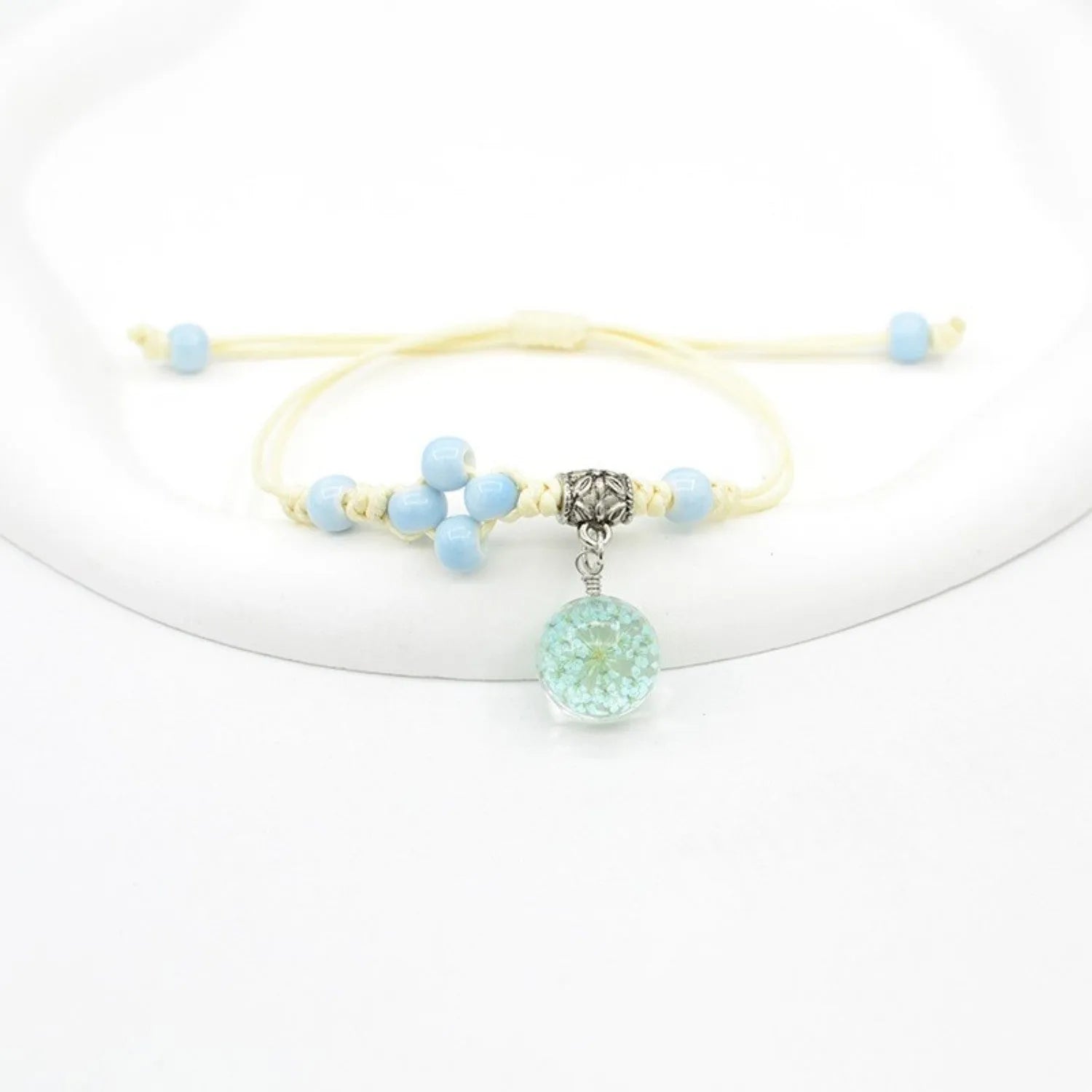 Women's hand-woven glass bracelet with large 1.4cm beads containing dried flowers, shown in blue colour option