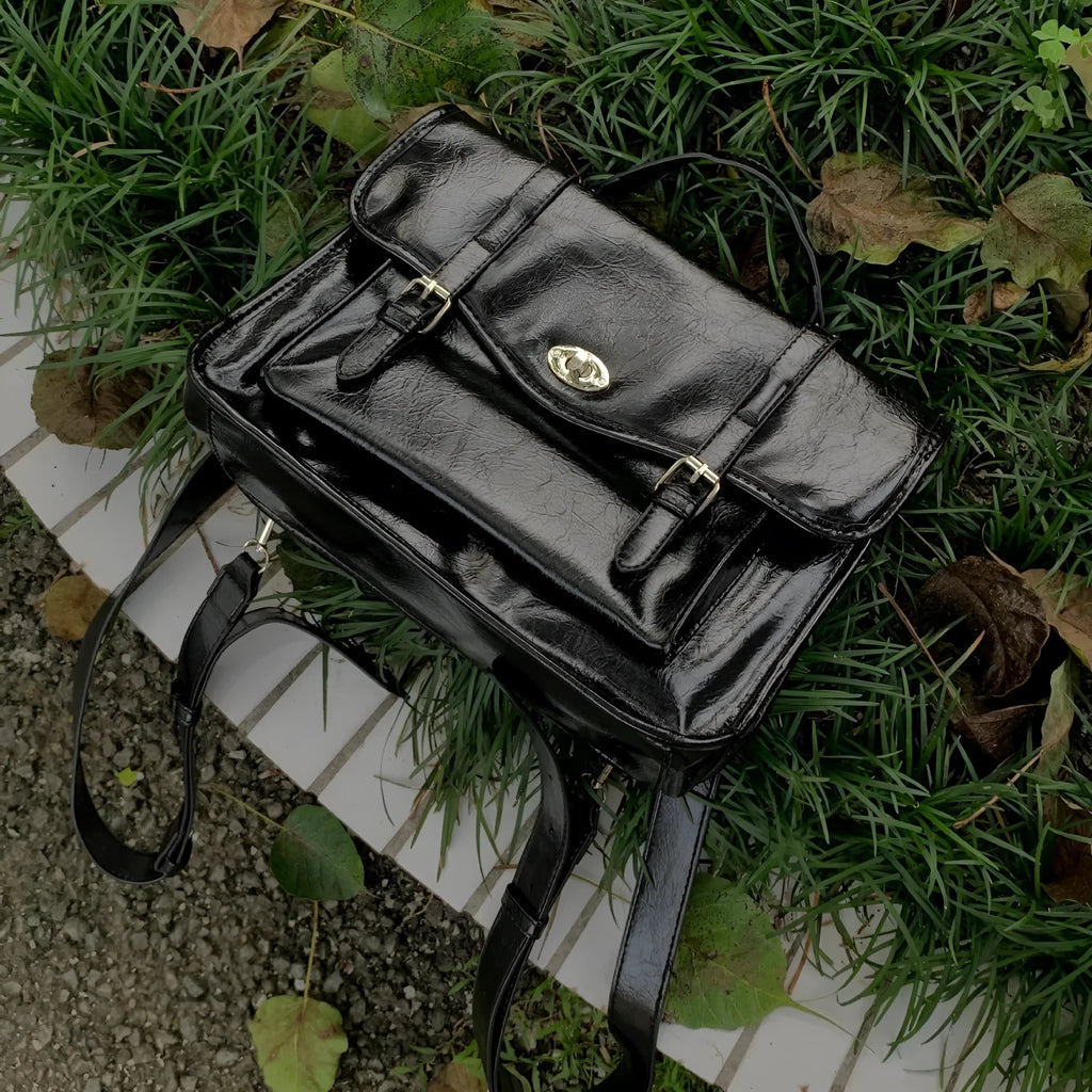 Black college style messenger bag with oil wax leather aesthetic showing shoulder strap and main compartment