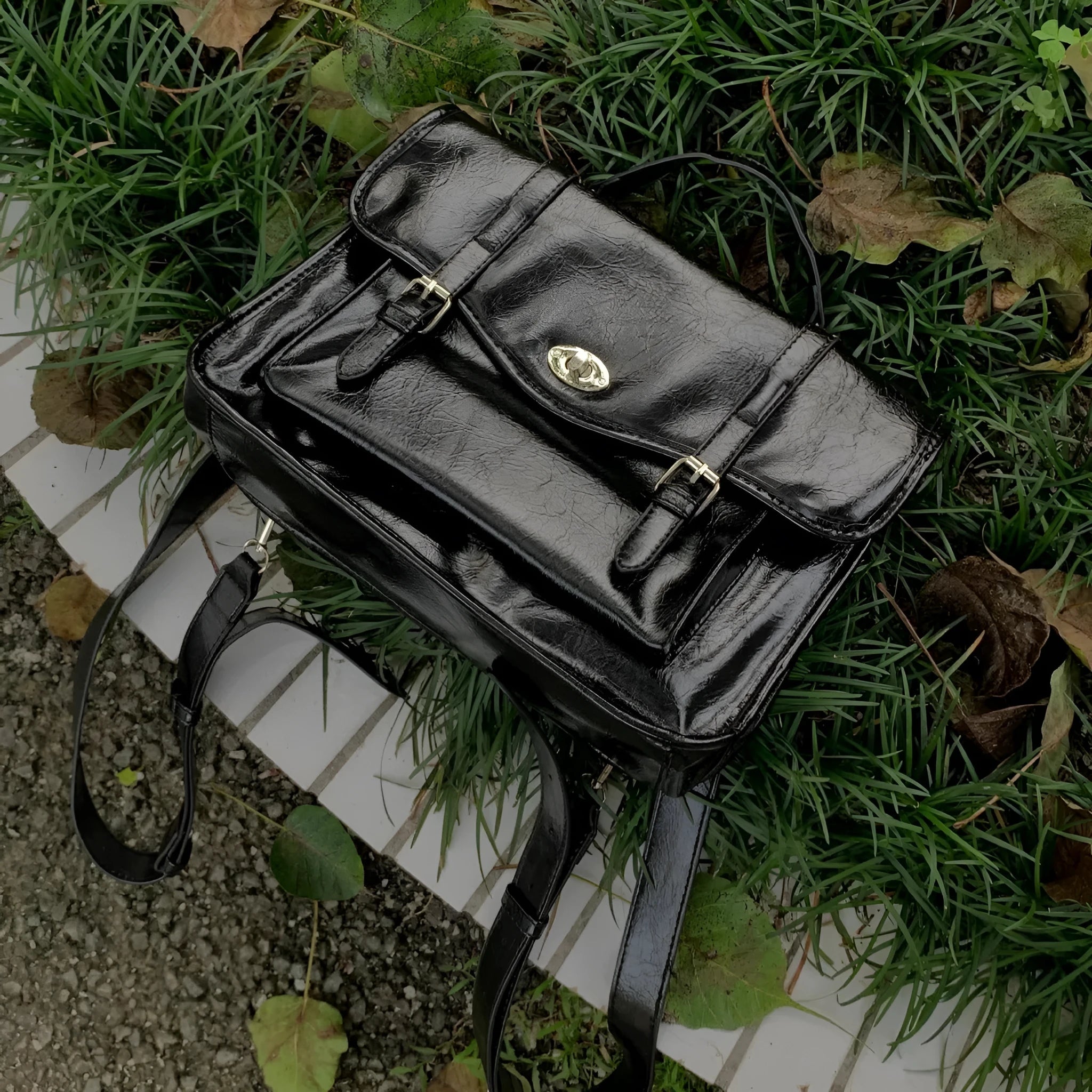 Black college style messenger bag with oil wax leather aesthetic showing shoulder strap and main compartment