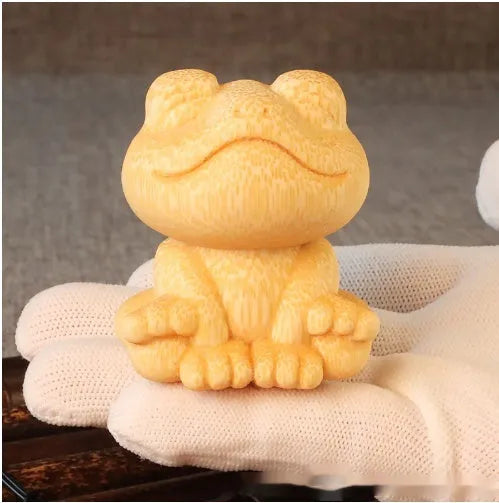 Solid bamboo smiling frog carving ornament next to a 120ml oil glove brush.