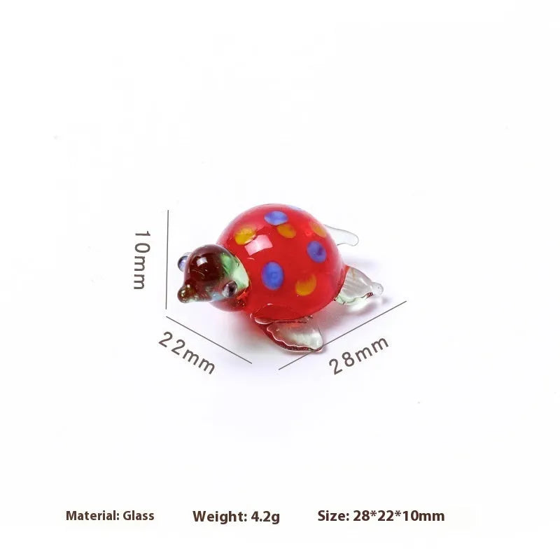 Glass geometric turtle ornament in blue head with blue shell colour variation on wooden desktop