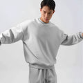 Men's polar fleece sports suit showing loose long sleeve coat and padded trousers in army green.