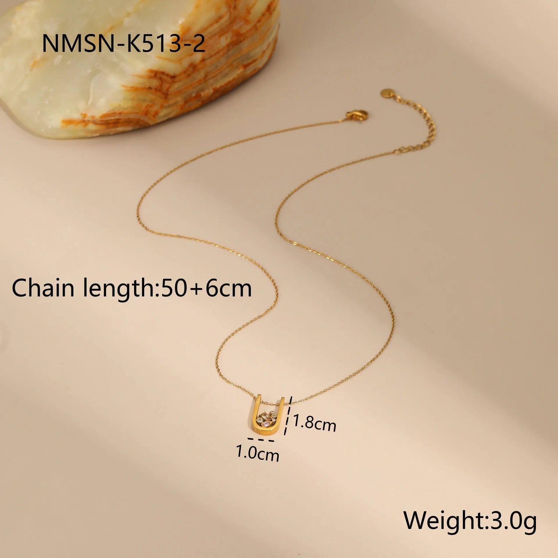 Geometric gold plated jewellery set on display showing drop necklace, U shape necklace, ring, and earrings with zircon accents.