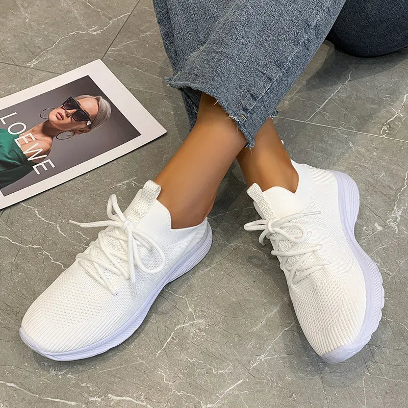 Women's mesh running shoes in creamy white with Flyknit upper and rubber sole